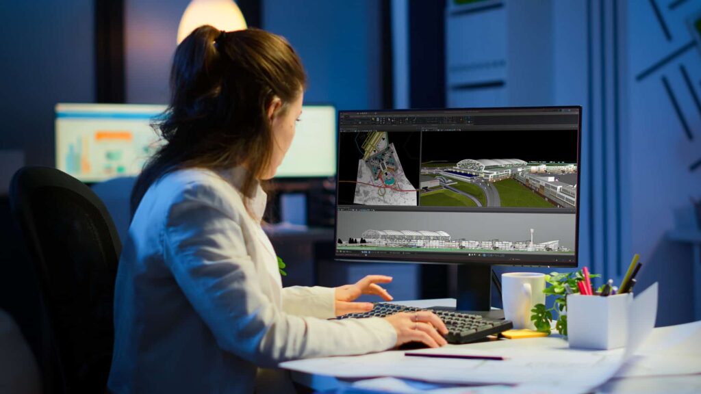 A woman working on a cad project on her computer in an office at night. | Bentley Systems | Infrastructure Engineering Software Company A woman working on a cad project on her computer in an office at night.