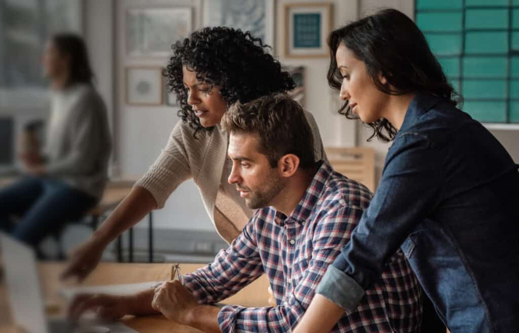three people working at a computer | Bentley Systems | Infrastructure Engineering Software Company three people working at a computer