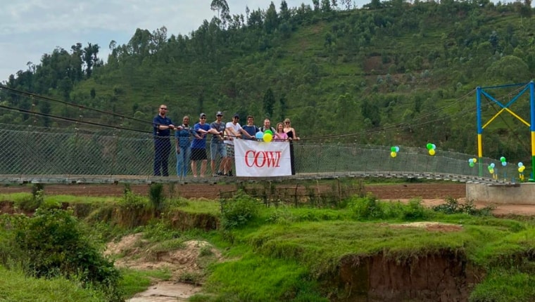Volunteers in Rwanda standing on a suspension bridge