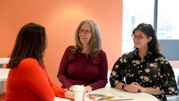 Three woman talking at a table