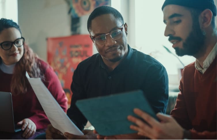 Three people looking at documents