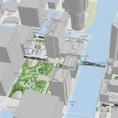 A 3D map of an urban area with a river running through it. There are several buildings, green spaces, and a bridge over the river, created through detailed digital modeling by Arcadis. | Bentley Systems | Infrastructure Engineering Software Company A 3D map of an urban area with a river running through it. There are several buildings, green spaces, and a bridge over the river, created through detailed digital modeling by Arcadis.
