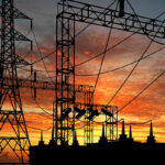 power lines and electrical station back lite from a sunset