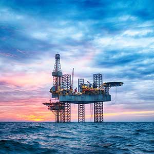 Offshore oil rig against a twilight sky.