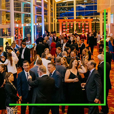 A group of well-dressed individuals engaging in conversation at an indoor social event.