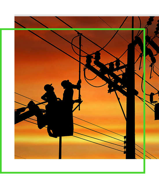 Silhouette two electricians with disconnect stick tool on crane truck are working to install electrical transmission on power pole stock photo | Bentley Systems | Infrastructure Engineering Software Company Silhouette two electricians with disconnect stick tool on crane truck are working to install electrical transmission on power pole stock photo