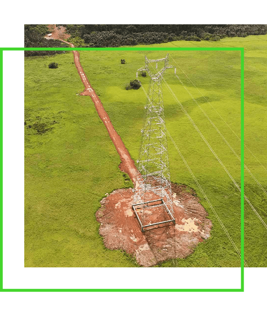 An aerial view of an electricity pylon in a green field. | Bentley Systems | Infrastructure Engineering Software Company An aerial view of an electricity pylon in a green field.